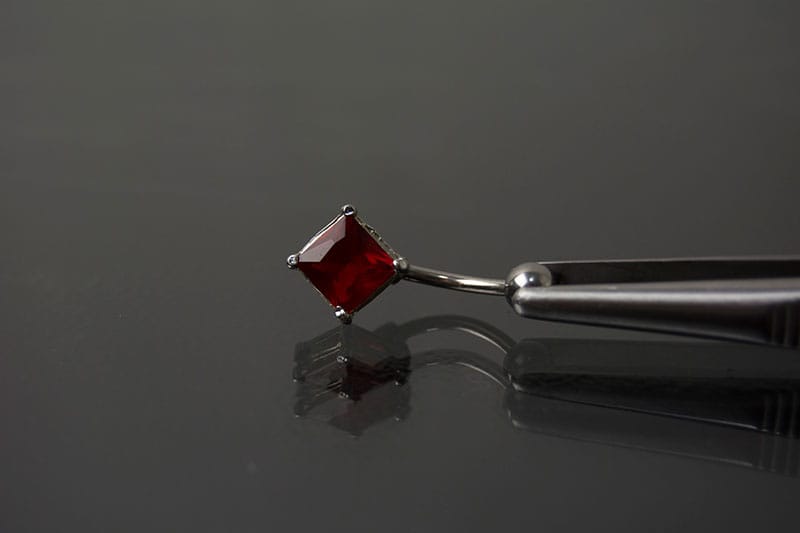 Navel acero joya roja